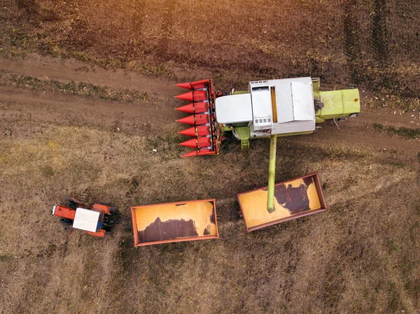 Vista aérea de la combinación de verter granos de maíz cosechados en el remolque —  Fotos de Stock