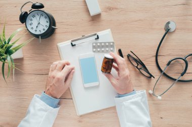 Çeşitli ilaçlar ve medica etiketlenmemiş şişe tutan erkek doktor