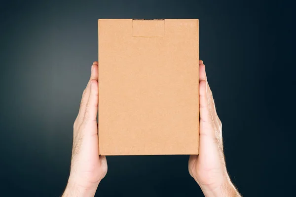 Man holding cardboard box package for mock up design — Stock Photo, Image