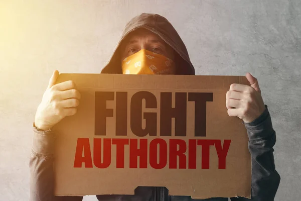 Hooded activist protestor holding Fight authority protest sign — Stock Photo, Image
