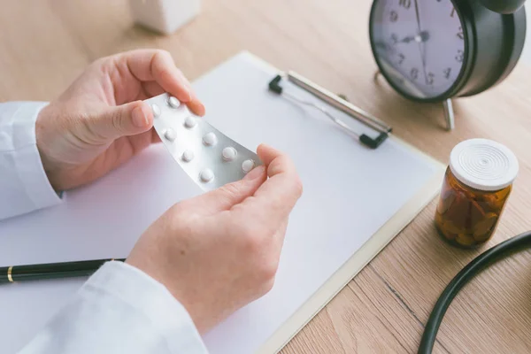 Médica feminina segurando comprimidos genéricos não rotulados — Fotografia de Stock