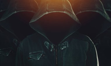 Group of hooded computer hackers with obscured faces