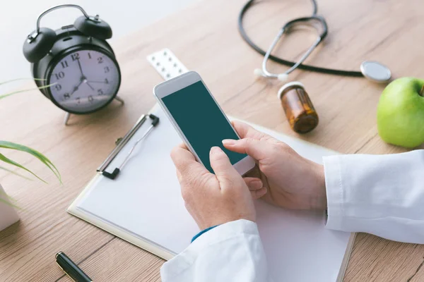 Lekarz za pomocą aplikacji na smartfony w szpitalu office — Zdjęcie stockowe