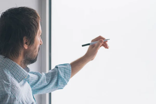 Businessman in office writing on whiteboard