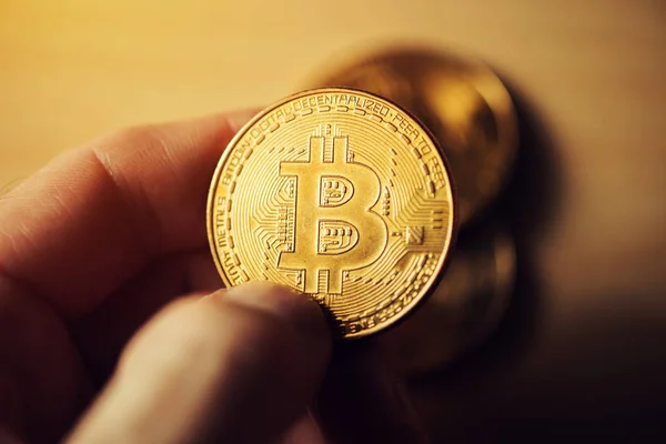 Nahaufnahme einer männlichen Hand, die Bitcoin hält — Stockfoto