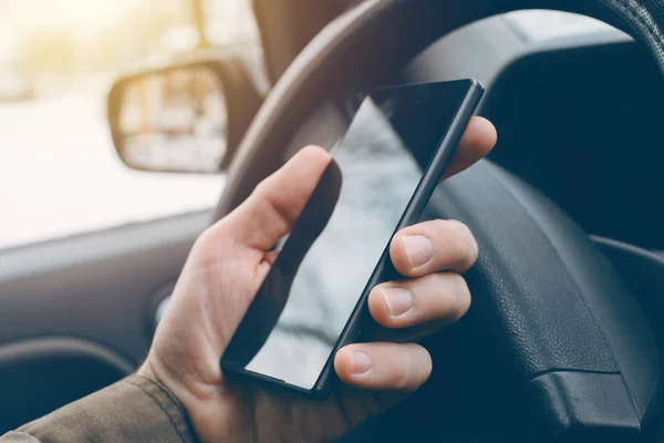 Чоловік керує автомобілем і використовує мобільний телефон для смс — стокове фото