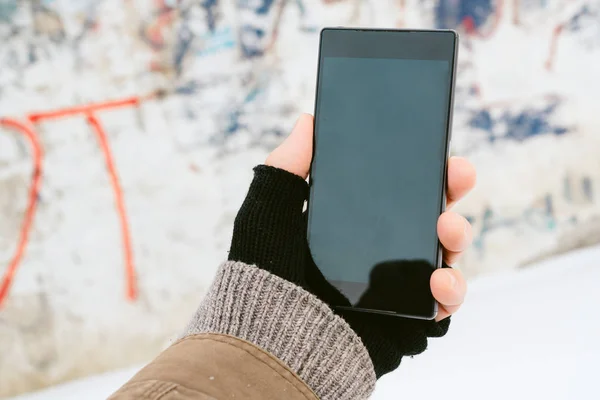 Mužské ruky držící smartphone venku v zimě — Stock fotografie