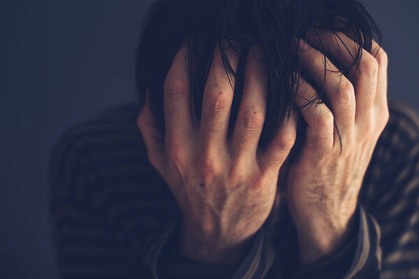 Безнадежный наркоман держит голову
