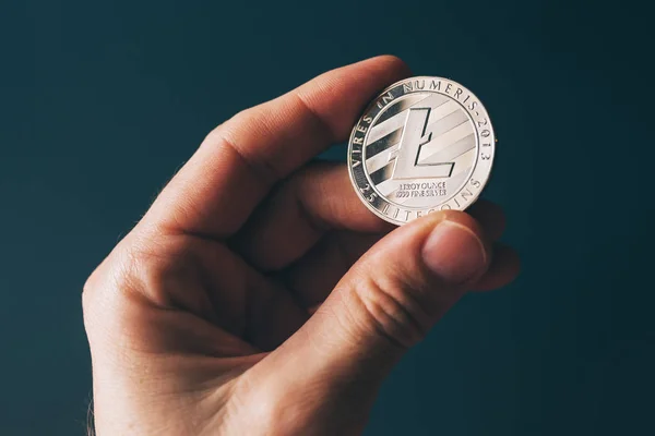 Litecoin cryptocurrency in hand — Stock Photo, Image