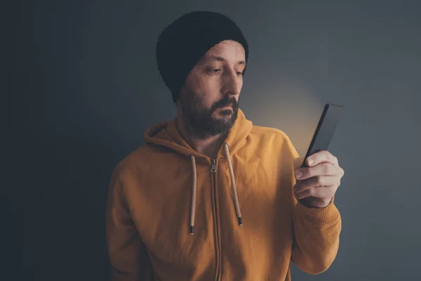 Человек смотрит на экран своего смартфона — стоковое фото