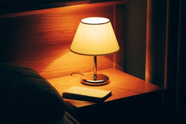 Otel odasında gece masada kitap ve vintage lamba
