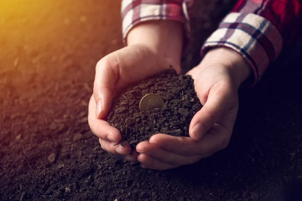 Eine Ein-Euro-Münze in einer Handvoll Erde — Stockfoto