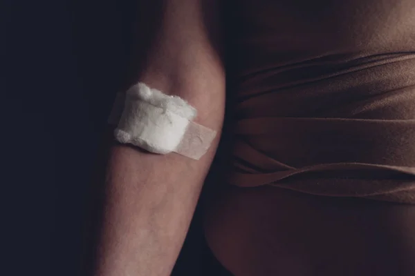 Laine de coton sur la main féminine après test sanguin de ponction veineuse — Photo