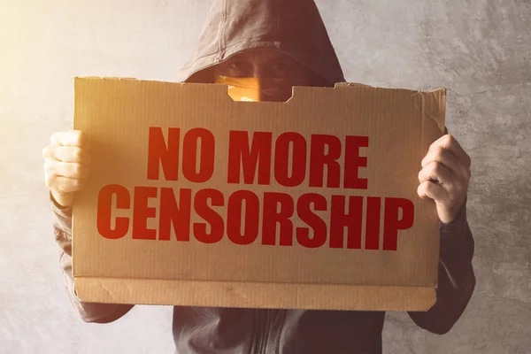 Hooded activist protestor holding No More Censorship protest sig