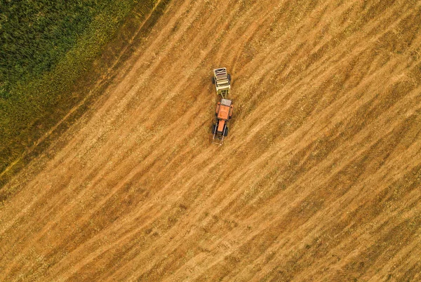 Vista aerea del trattore che fa rotoli di balle di fieno in campo — Foto Stock