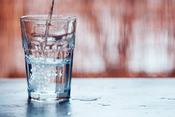 Gieten van koolzuurhoudende water in het glas drinken — Stockfoto