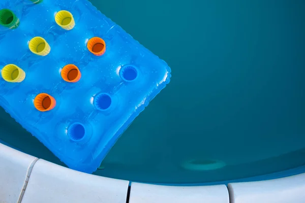 Inflatable mattress floating on swimming pool surface — Stock Photo, Image