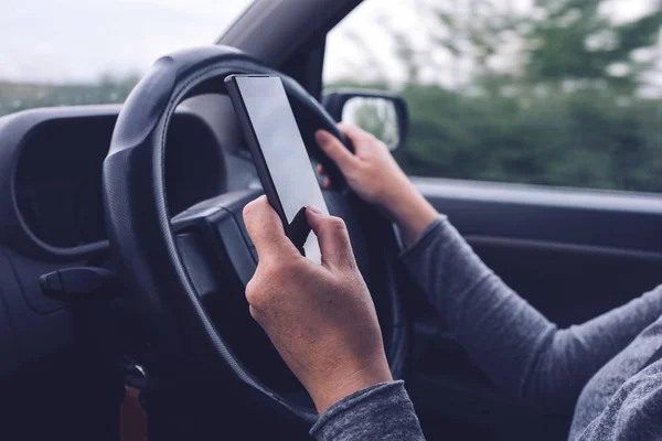 Kobieta, jednocześnie jazdy samochodem i wpisywanie wiadomości tekstowej — Zdjęcie stockowe