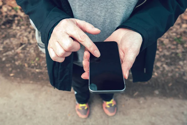 Primer plano de las manos femeninas con smartphone al aire libre — Foto de Stock