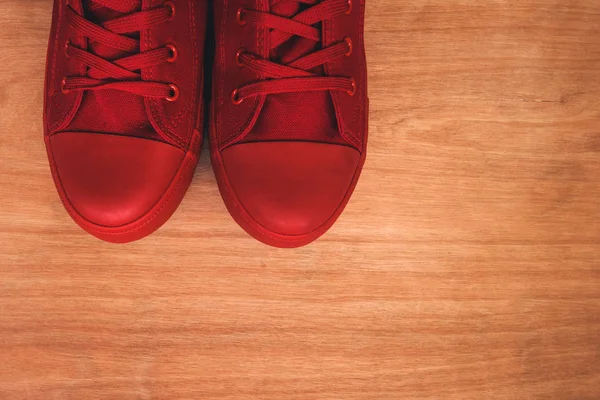 Eleganti scarpe da ginnastica rosse su sfondo di legno — Foto Stock