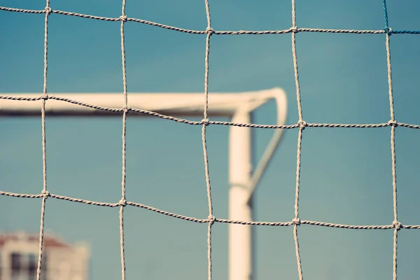 European football or soccer goal defocussed in background — Stock Photo, Image