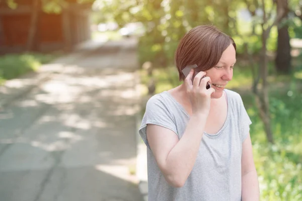 Mutlu kadın sokakta cep telefonunda söz gülümseyen — Stok fotoğraf