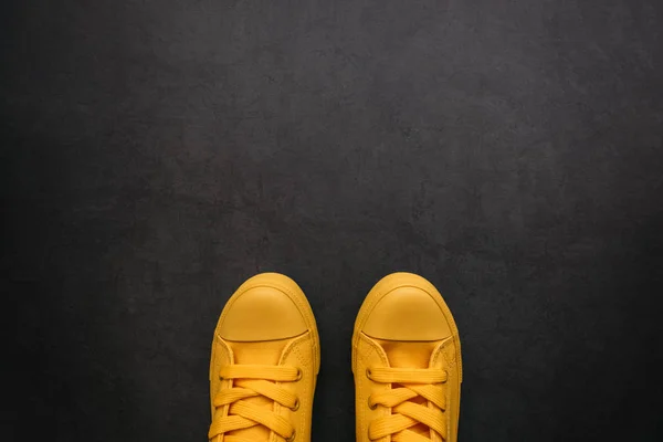 Stylish yellow sneakers on dark background — Stock Photo, Image