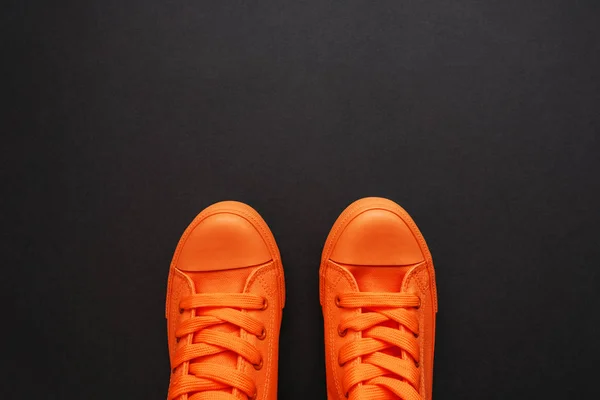 Stylish orange sneakers on dark background — Stock Photo, Image