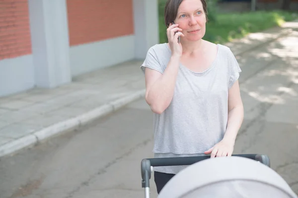 Gelukkig moeder praten op mobiele telefoon — Stockfoto