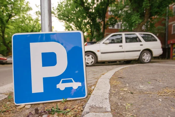 Sinal de estacionamento com carro em fundo embaçado — Fotografia de Stock