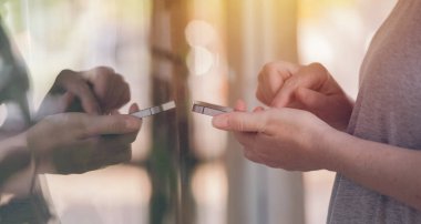 Mağaza vitrin önünde istimal hareket eden telefon. Smartphone aygıt tutarak ve fiyatları kontrol etmek için app kullanarak eller. Seçici odak.