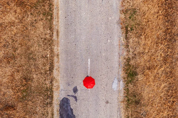 Roter Regenschirm auf der Straße, Draufsicht — Stockfoto