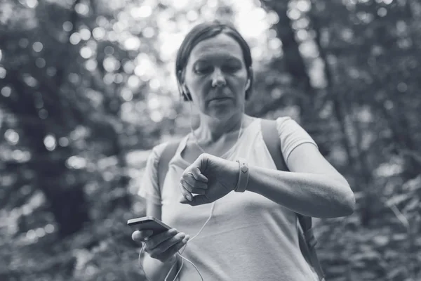 Női túrázó ellenőrzése fitness tracker csuklópánt adatok — Stock Fotó