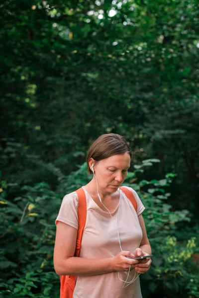 Caminhante feminina usando smartphone na floresta — Fotografia de Stock