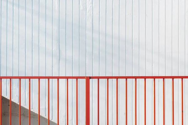 Red steel bar fence and white stripped wall — ストック写真