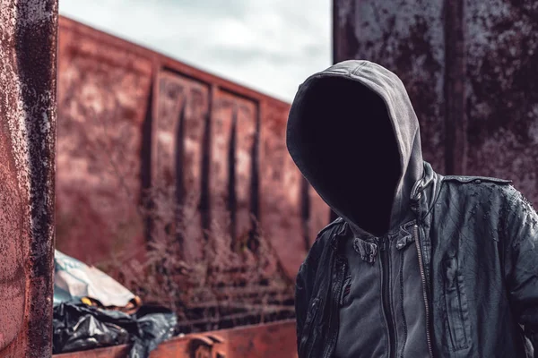 Faceless hooded homeless man among old obsolete freight train wa — Stock Photo, Image