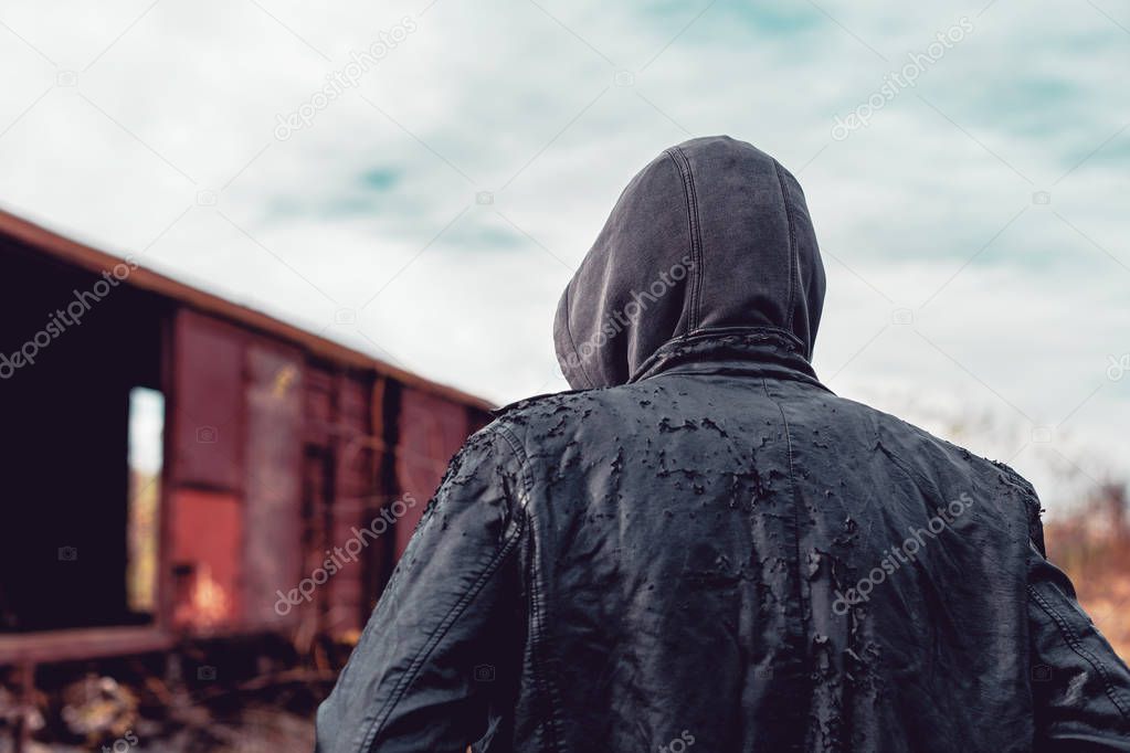 Homeless immigrant walking by freight train wagons