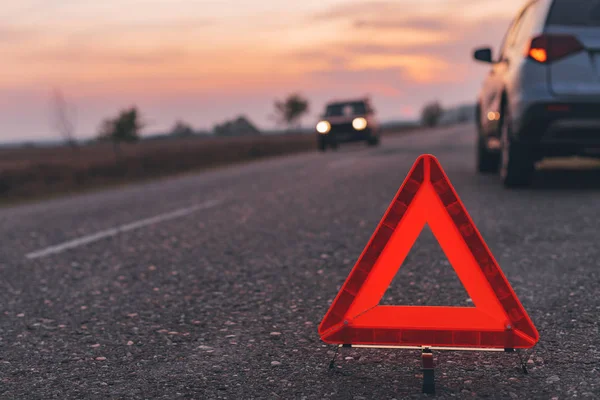 Segnale di avvertimento triangolo sulla strada al tramonto — Foto Stock