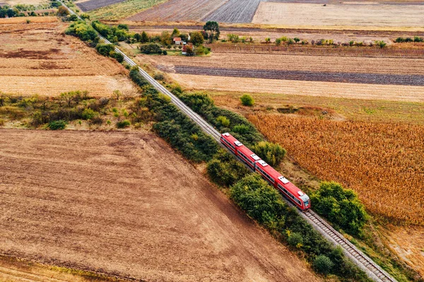 Tren rojo de pasajeros que viaja por el campo, vista aérea —  Fotos de Stock