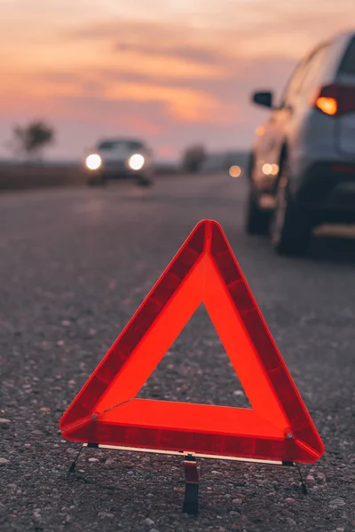 Znak trójkąta ostrzegawczego na drodze o zachodzie słońca — Zdjęcie stockowe