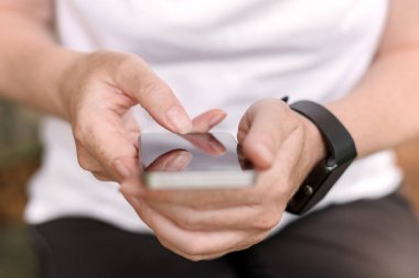 Akıllı telefon ve dinlenirken akıllı saat kullanan kadın yürüyüşçü