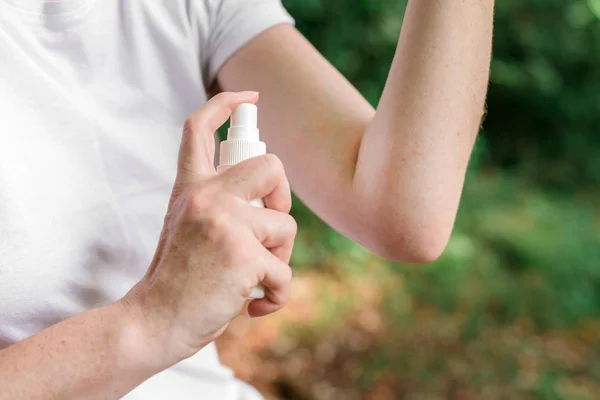 Vrouwelijke wandelaar met behulp van antiseptische spray buiten — Stockfoto