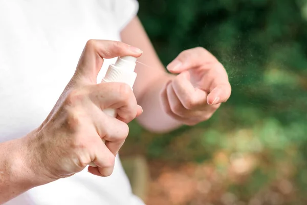 Female hiker using antiseptic spray outdoors — Stock Photo, Image