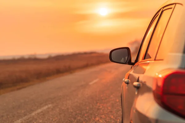 Espejo de vista lateral del coche en la carretera en otoño puesta de sol —  Fotos de Stock