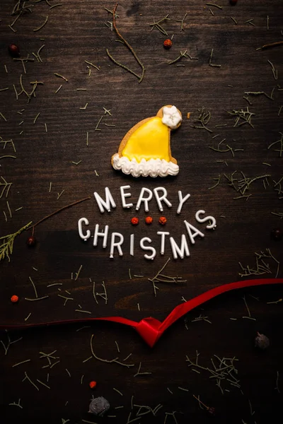 Feliz Navidad texto con pan de jengibre Santa Claus sombrero — Foto de Stock