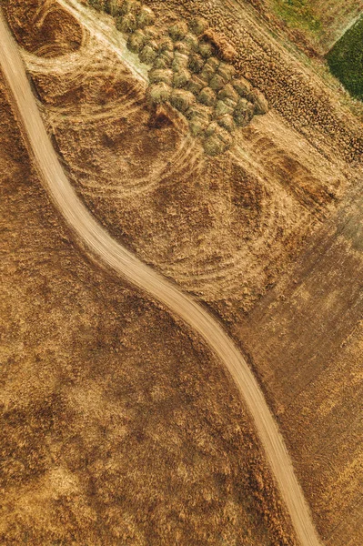 Vista aérea del camino de tierra polvorienta a través de paisaje llano herboso —  Fotos de Stock