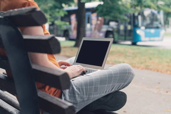 Женщина с ноутбуком на уличной скамейке, макет экрана — стоковое фото