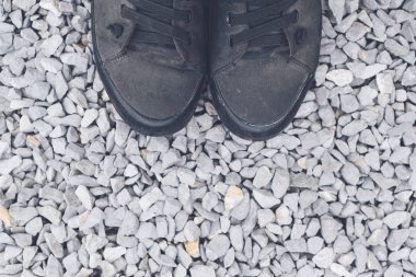 Mavi çakıl taşı zemininde, yukarıdan gelen spor ayakkabıları