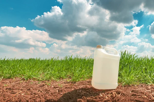 Recipiente de jarro de pesticida em branco simular no campo de wheatgrass — Fotografia de Stock