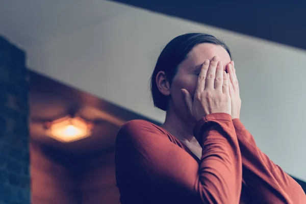 Depressieve vrouw bedekt gezicht met handen en huilen — Stockfoto